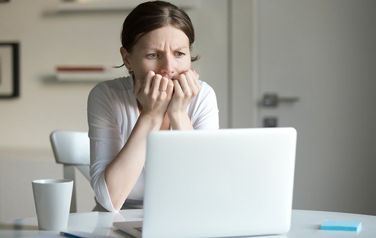 Social Media Marketing Mistakes You Need to Avoid Portrait of a young woman at desk with laptop, fear